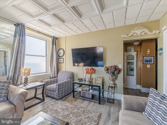 living room featuring wood-type flooring and coffered ceiling