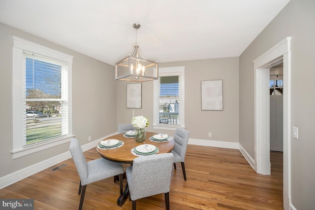 dining area with a wealth of natural light and hardwood / wood-style flooring