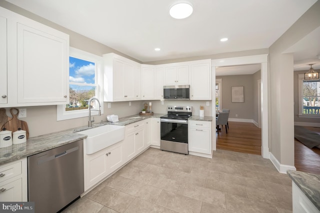 kitchen featuring sink, white cabinets, light wood-type flooring, and appliances with stainless steel finishes