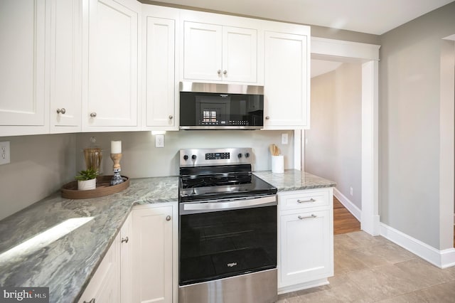 kitchen with white cabinets, light stone countertops, stainless steel appliances, and light tile patterned floors