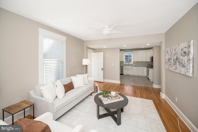 living room featuring ceiling fan and light hardwood / wood-style floors