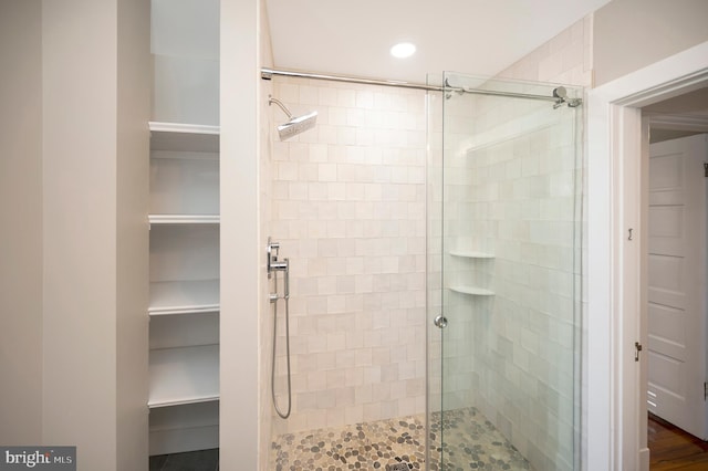 bathroom with hardwood / wood-style floors and a shower with door