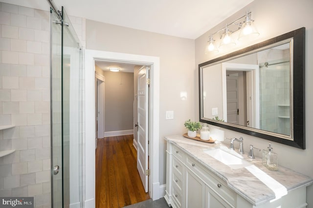 bathroom featuring hardwood / wood-style floors, vanity, and walk in shower