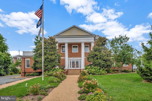 neoclassical / greek revival house featuring a front lawn and french doors