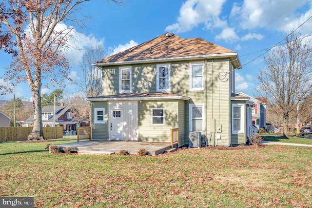 view of front of house with a front lawn and central air condition unit