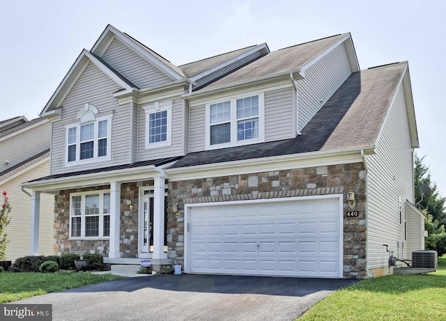 view of front of property featuring central AC unit and a garage