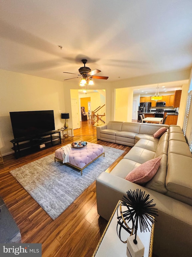 living room featuring hardwood / wood-style floors and ceiling fan