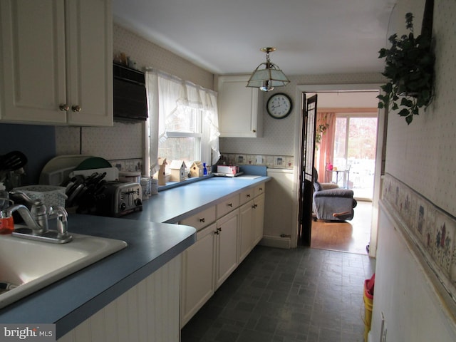 kitchen featuring white cabinets, dark hardwood / wood-style floors, sink, and hanging light fixtures