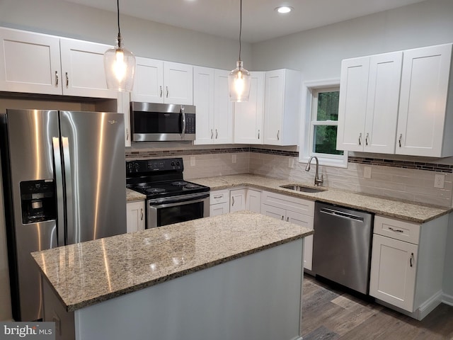 kitchen with backsplash, sink, appliances with stainless steel finishes, light stone counters, and white cabinetry