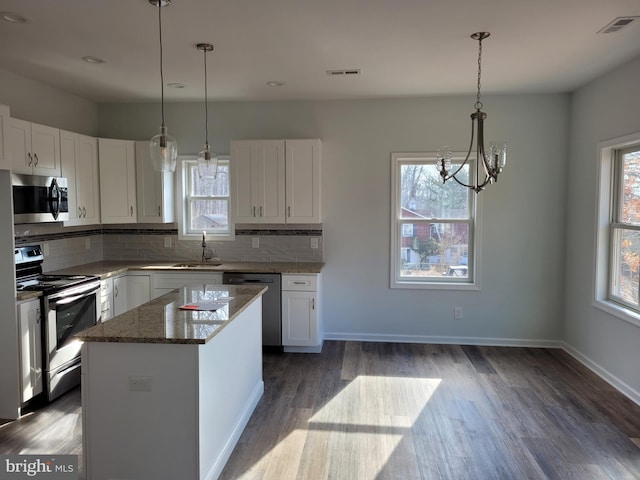 kitchen featuring white cabinets, a center island, sink, and appliances with stainless steel finishes