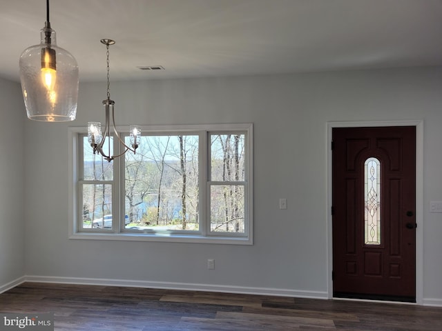 entrance foyer with dark wood-type flooring and a notable chandelier