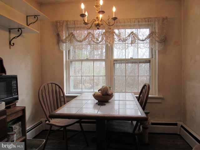 dining area with a chandelier, dark hardwood / wood-style flooring, a healthy amount of sunlight, and a baseboard heating unit