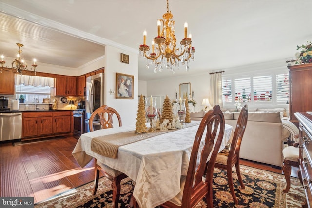 dining space with crown molding, plenty of natural light, dark wood-type flooring, and a notable chandelier