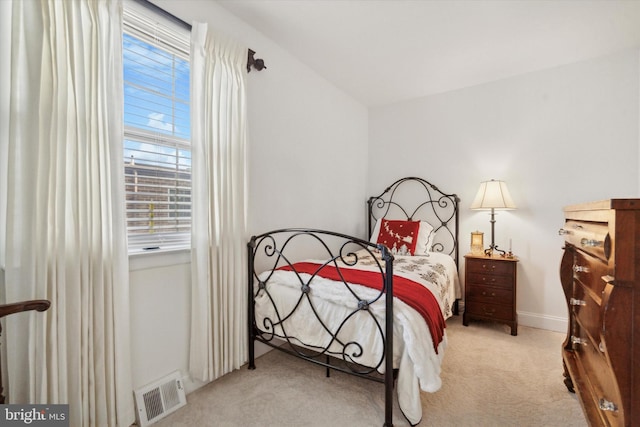 bedroom with light colored carpet and lofted ceiling