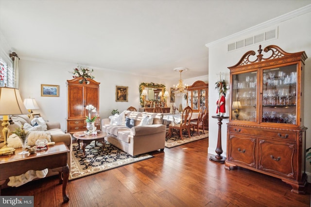 living room featuring a notable chandelier, dark hardwood / wood-style flooring, and crown molding