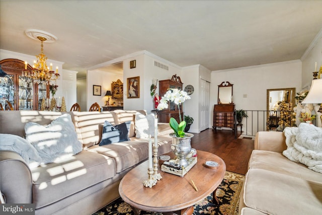 living room with dark hardwood / wood-style floors, ornamental molding, and an inviting chandelier