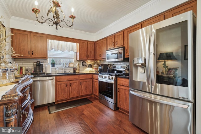 kitchen with dark wood-type flooring, an inviting chandelier, sink, tasteful backsplash, and stainless steel appliances