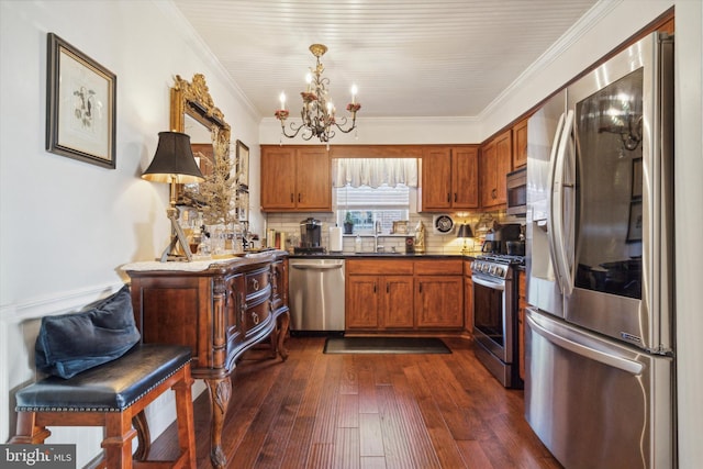 kitchen with dark hardwood / wood-style flooring, ornamental molding, stainless steel appliances, sink, and decorative light fixtures