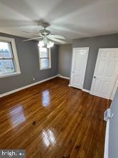 unfurnished bedroom featuring dark hardwood / wood-style flooring and ceiling fan