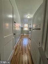 hallway with hardwood / wood-style flooring