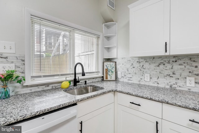 kitchen featuring stainless steel dishwasher, light stone counters, white cabinetry, and sink