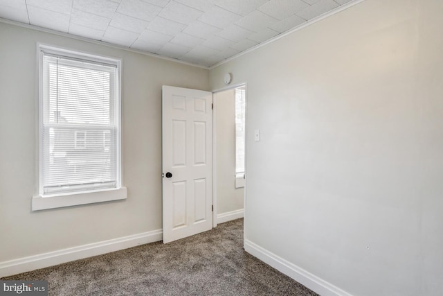 carpeted spare room featuring crown molding