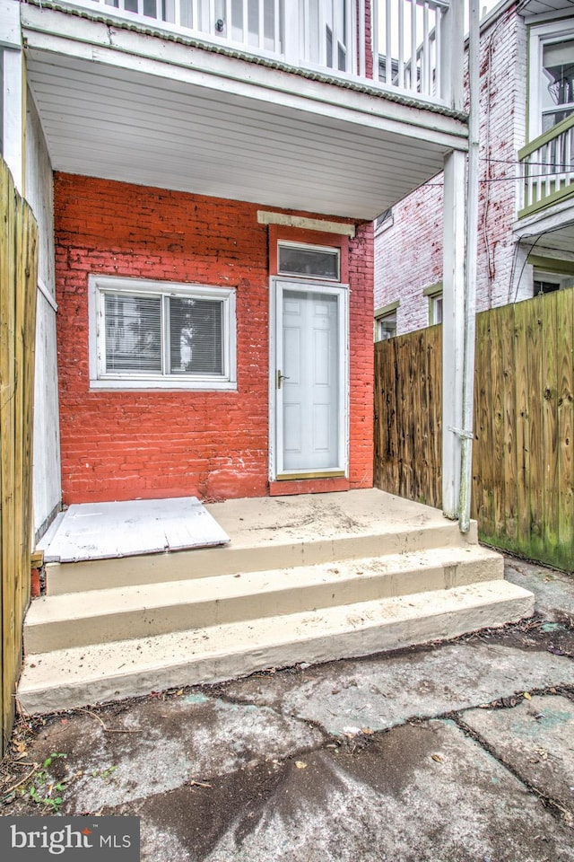 view of exterior entry with a balcony