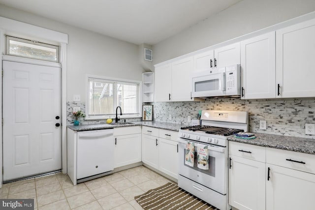 kitchen with white appliances, white cabinetry, and sink