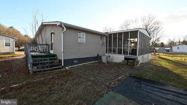 back of property with a wooden deck and a sunroom