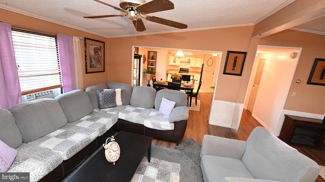 living room with hardwood / wood-style floors, a textured ceiling, ceiling fan, and ornamental molding