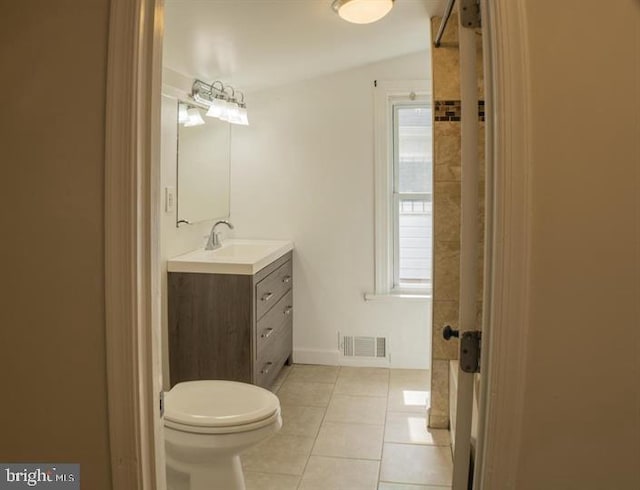 bathroom with tile patterned flooring, vanity, vaulted ceiling, and toilet