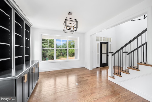 interior space featuring light hardwood / wood-style floors and an inviting chandelier