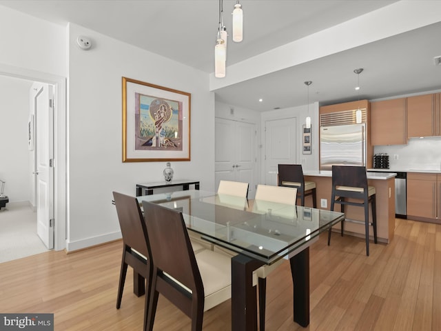 dining room with baseboards and light wood finished floors