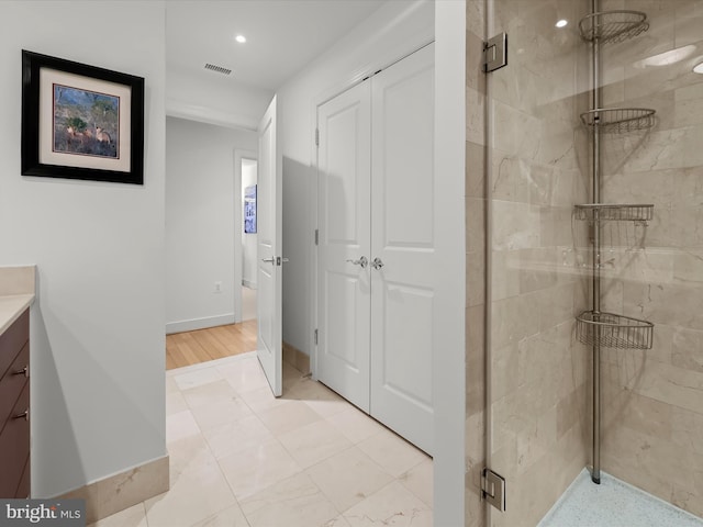 bathroom featuring baseboards, visible vents, a shower stall, and vanity