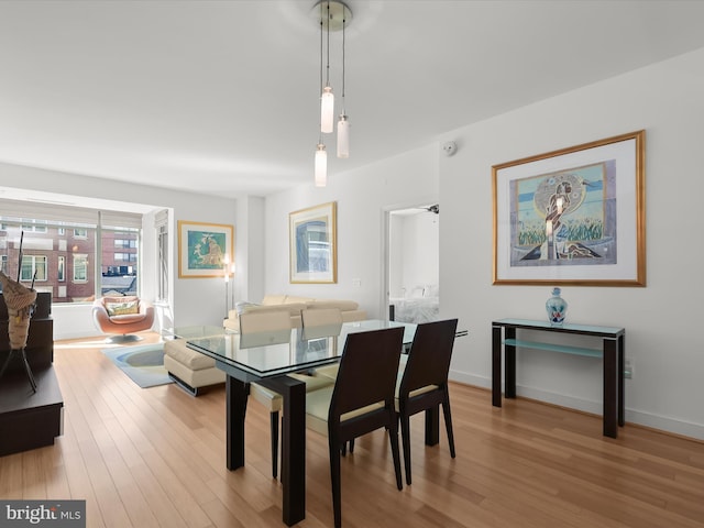 dining room with baseboards and light wood finished floors