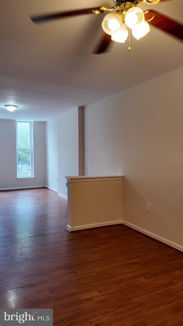 unfurnished room with dark hardwood / wood-style floors and ceiling fan