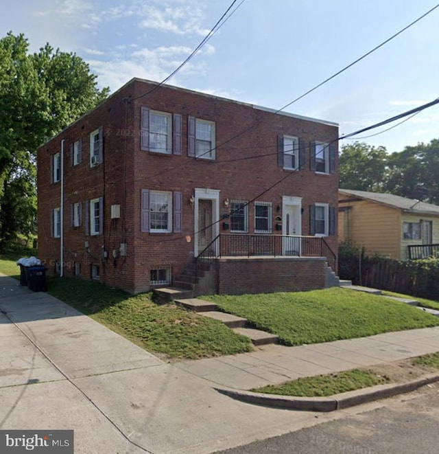 townhome / multi-family property featuring brick siding and a front lawn