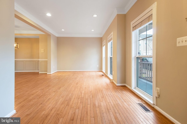 unfurnished room with light wood-type flooring and ornamental molding