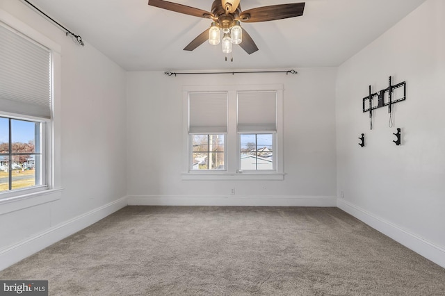 carpeted spare room featuring ceiling fan