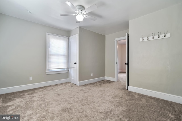 carpeted empty room featuring ceiling fan