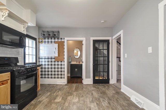 kitchen with decorative backsplash, sink, dark hardwood / wood-style floors, and black appliances