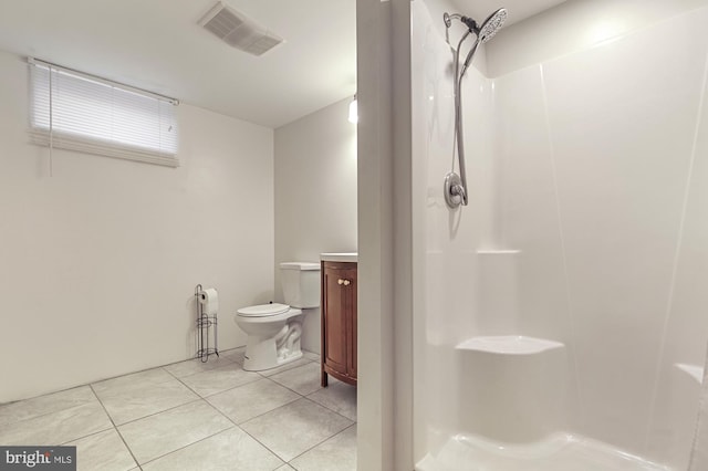 bathroom featuring tile patterned flooring, toilet, a shower, and vanity