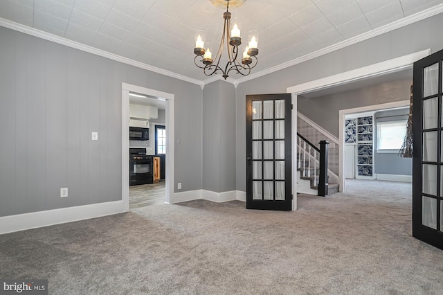 spare room featuring carpet, ornamental molding, french doors, and a notable chandelier