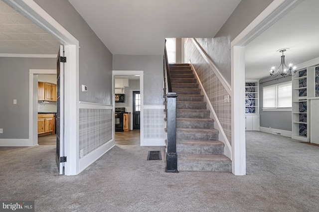 staircase featuring carpet, a notable chandelier, and crown molding