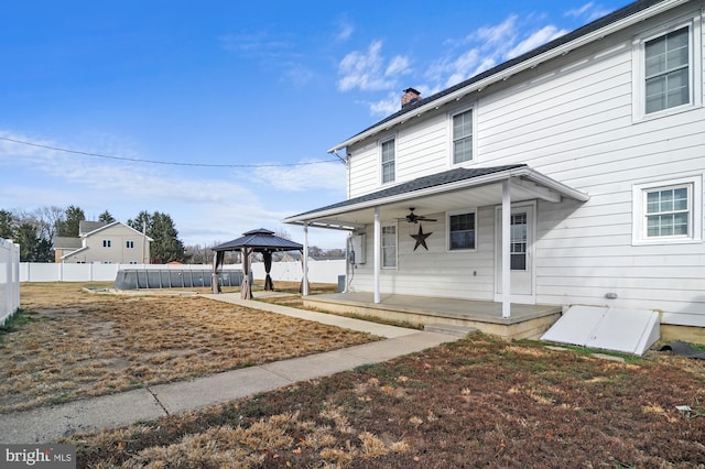 rear view of property featuring a gazebo