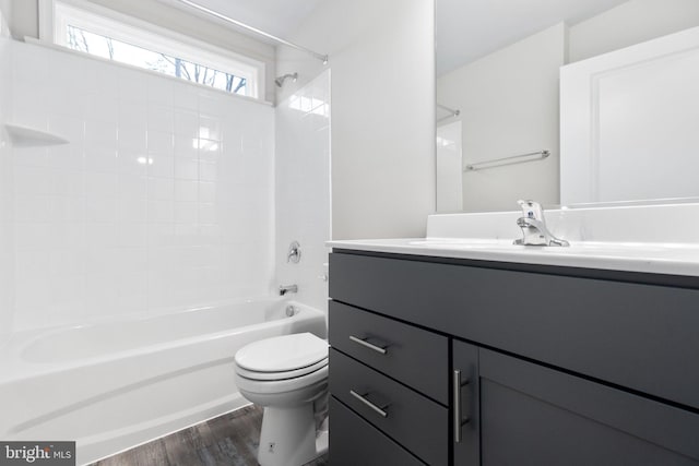 full bathroom with tiled shower / bath, toilet, vanity, and hardwood / wood-style flooring