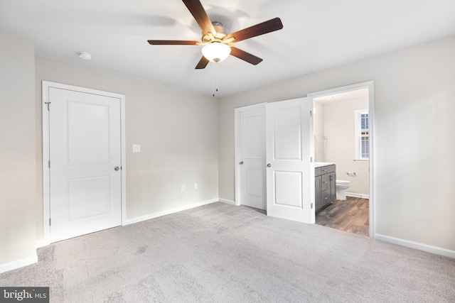 unfurnished bedroom featuring connected bathroom, light colored carpet, and ceiling fan