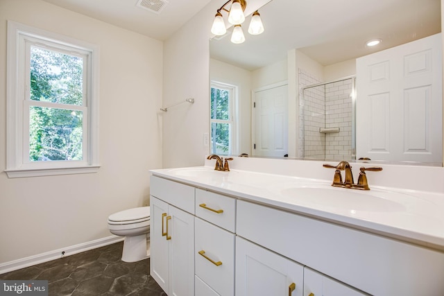 bathroom featuring tile patterned flooring, vanity, toilet, and tiled shower