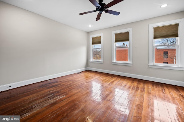 unfurnished room with hardwood / wood-style flooring, ceiling fan, and a healthy amount of sunlight