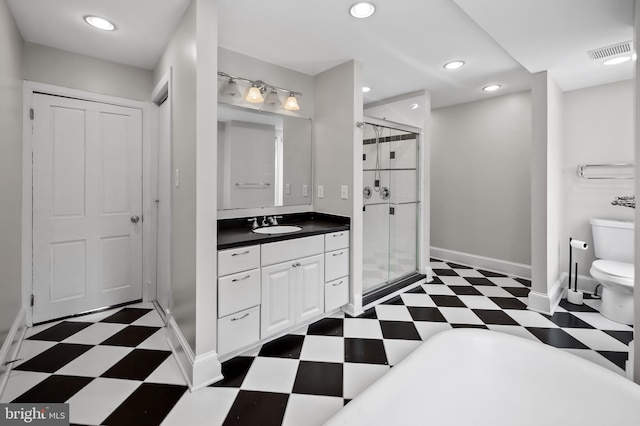 bathroom featuring vanity, toilet, and a shower with door